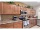 Modern kitchen with stainless steel appliances and wood cabinets at 1825 N Lewis Pl, Casa Grande, AZ 85122