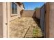 Small side yard with dry grass and a metal gate at 1825 N Lewis Pl, Casa Grande, AZ 85122