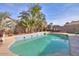 Relaxing kidney-shaped pool surrounded by palm trees and a patio area at 18489 N Davis Dr, Maricopa, AZ 85138