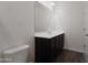 Simple bathroom with a toilet and dark vanity at 20249 W Woodlands Ave, Buckeye, AZ 85326