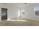 Spacious bedroom with neutral carpeting and two windows at 20249 W Woodlands Ave, Buckeye, AZ 85326