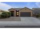 Single-story home with a two-car garage and desert landscaping at 20249 W Woodlands Ave, Buckeye, AZ 85326