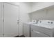 Bright laundry room with washer, dryer, and ample shelving at 20249 W Woodlands Ave, Buckeye, AZ 85326