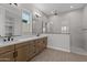 Bright bathroom featuring double sinks, wood cabinets, a walk-in shower, and modern fixtures at 21537 W Pierson St, Buckeye, AZ 85396