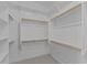 Spacious walk-in closet with shelving and wooden rods for ample storage space at 21537 W Pierson St, Buckeye, AZ 85396