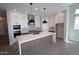 Spacious kitchen featuring white cabinets, a large center island, and stainless steel appliances at 21537 W Pierson St, Buckeye, AZ 85396