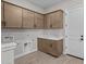 Functional laundry room featuring modern cabinetry, a sink, and tile flooring at 21537 W Pierson St, Buckeye, AZ 85396