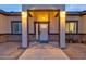 Modern house entrance with lighted columns and stone accents at 23527 W Estes Way, Buckeye, AZ 85326