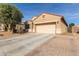 Tan house with a two-car garage and brick paver driveway at 23802 W Tamarisk Ave, Buckeye, AZ 85326