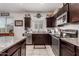 Kitchen with dark cabinets, granite countertops, and a double sink at 23802 W Tamarisk Ave, Buckeye, AZ 85326