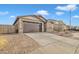 Single story home with a two-car garage, and desert landscaping at 2562 N Abbey Rd, Casa Grande, AZ 85122