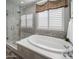 Elegant bathroom with soaking tub, glass shower, and stylish tile at 26698 N 104Th Way, Scottsdale, AZ 85262