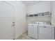 Functional laundry room with washer, dryer, and shelving at 29308 N 132Nd Ln, Peoria, AZ 85383