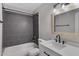 Updated bathroom with gray tile, white vanity, and black fixtures at 2968 E Clarendon Ave, Phoenix, AZ 85016