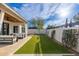 A serene backyard featuring artificial grass, a seating area, and stylish white walls at 3427 E Campbell Ave, Phoenix, AZ 85018