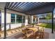 This outdoor space offers a wooden table under a pergola with stone pavers at 3427 E Campbell Ave, Phoenix, AZ 85018