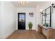 Bright and airy entryway with a black door, wood console table, and large mirrors at 3427 E Campbell Ave, Phoenix, AZ 85018