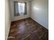 Bedroom with wood-look flooring and window with curtains at 3646 N 69Th Ave # 55, Phoenix, AZ 85033