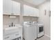 Well-equipped laundry room with washer, dryer, and utility sink at 37029 N Andravida Dr, San Tan Valley, AZ 85140