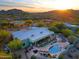 Aerial view of a luxurious home with a large pool and breathtaking mountain backdrop at 38844 N Spur Cross Rd, Cave Creek, AZ 85331