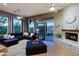 Bright living room with stone fireplace and sliding doors to patio at 38844 N Spur Cross Rd, Cave Creek, AZ 85331