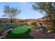 Landscaped backyard oasis with putting green and water feature at 38844 N Spur Cross Rd, Cave Creek, AZ 85331