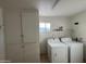 Laundry room with washer, dryer, and built-in storage at 5452 E University Dr, Mesa, AZ 85205