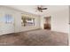 Bright living room with large window, carpet, and ceiling fan at 5452 E University Dr, Mesa, AZ 85205