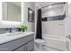 Modern bathroom with tub, gray vanity, and black accents at 5609 W Posse Dr, Eloy, AZ 85131