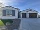 Two-story house with gray shutters, dark brown garage doors, and a landscaped front yard at 5609 W Posse Dr, Eloy, AZ 85131