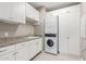 Bright laundry room with washer, dryer, cabinets, and granite countertop at 5609 W Posse Dr, Eloy, AZ 85131