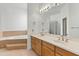 Elegant bathroom with double sinks, bathtub, and glass block shower at 7110 W Villa Lindo Dr, Peoria, AZ 85383