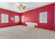 Red-walled bedroom with carpet flooring and ceiling fan at 7110 W Villa Lindo Dr, Peoria, AZ 85383