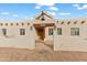 Home's entrance featuring a wooden door and arched entryway with stucco walls at 7110 W Villa Lindo Dr, Peoria, AZ 85383