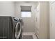 Bright laundry room, featuring modern washer and dryer, built-in cabinetry, and window at 7227 E Texas Ebony Dr, Gold Canyon, AZ 85118