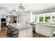 Island kitchen with white cabinetry, marble countertops, and a view into the living area at 7528 N 10Th St, Phoenix, AZ 85020