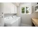 Bright laundry room with white cabinets, washer, dryer, and window at 7528 N 10Th St, Phoenix, AZ 85020