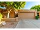 Tan stucco house with a two-car garage and mature landscaping at 921 E Becker Ln, Phoenix, AZ 85020