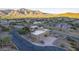 Aerial view of a modern house with desert landscaping, mountain views, and a private driveway at 9823 E Dead Sure Pl, Gold Canyon, AZ 85118