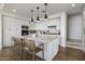 Modern kitchen with white cabinets, large island, and stainless steel appliances at 9909 E Lookout Mountain Dr, Scottsdale, AZ 85262