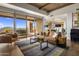 Living room with wood beams, fireplace and sliding doors to a patio at 9909 E Lookout Mountain Dr, Scottsdale, AZ 85262