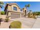 Two-story house with three-car garage and landscaped front yard at 13002 W Llano Dr, Litchfield Park, AZ 85340