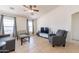 Living room with TV, gray couch, and ceiling fan at 1335 E Silver Brush Trl, Casa Grande, AZ 85122