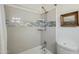 Bathroom with a shower-tub combo with tiled walls, mosaic border, and chrome shower fixture at 1632 E Maryland Ave, Phoenix, AZ 85016