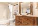 Rustic bathroom with wood vanity, bowl sink, tiled shower, and designer mirror at 18805 E Loredo Ln, Rio Verde, AZ 85263