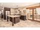 Gourmet kitchen with large center island, stone floors, dark wood cabinets, stainless steel appliances, and access to the backyard at 18805 E Loredo Ln, Rio Verde, AZ 85263