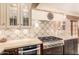 Gourmet kitchen featuring custom tile work, light countertops, stainless steel appliances and dark wood cabinets at 18805 E Loredo Ln, Rio Verde, AZ 85263