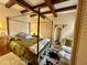 Main bedroom featuring a four poster bed, wood beamed ceilings and stone floors adding rustic charm to the space at 18805 E Loredo Ln, Rio Verde, AZ 85263