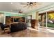 Bright Gathering room with wood shelving, leather couch, and sliding glass doors leading to backyard at 20089 N 263Rd Dr, Buckeye, AZ 85396