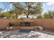 Stone fireplace in backyard with surrounding plants at 20089 N 263Rd Dr, Buckeye, AZ 85396